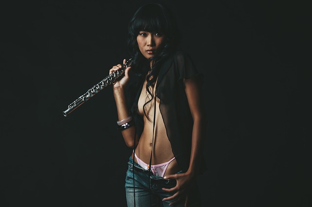 Sexy žena s flautou v ruke sa vyzlieka z nohavíc.jpg